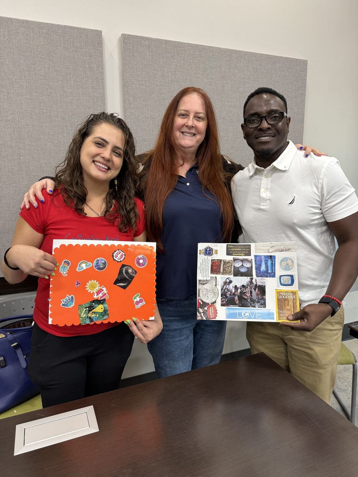 Two ACES staff members and a participant smiling together while holding the vision boards they made